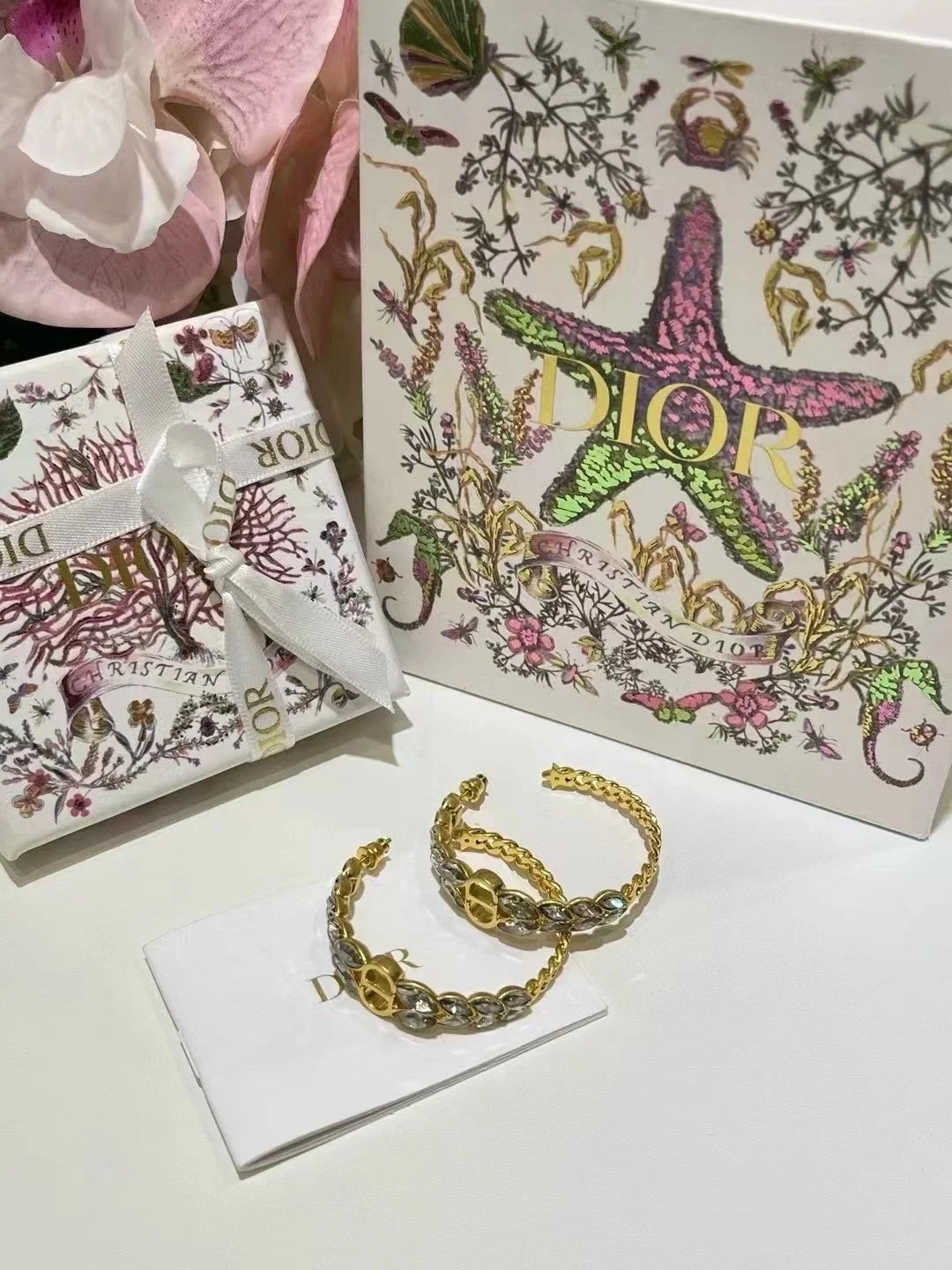 Orecchini a cerchio aperti Dior dorati con cristalli e catena a spiga
