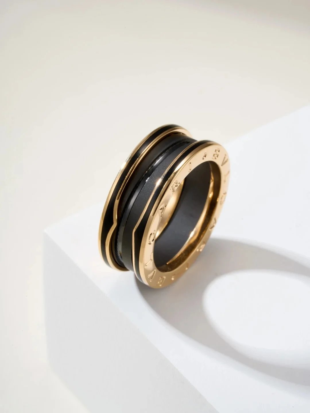 Anello a fascia nera con bordi incisi color oro