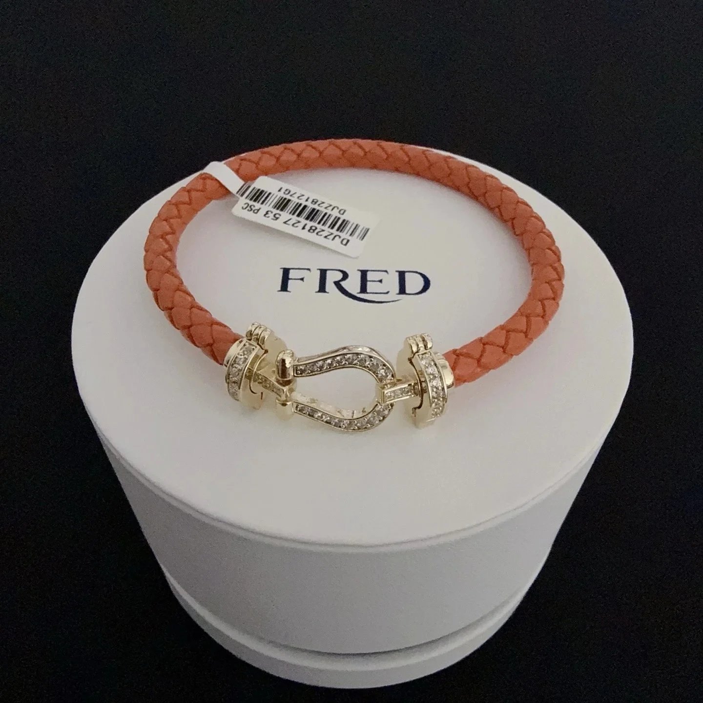 Armband mit Hufeisenverschluss und geflochtenem korallenorangefarbenem Band