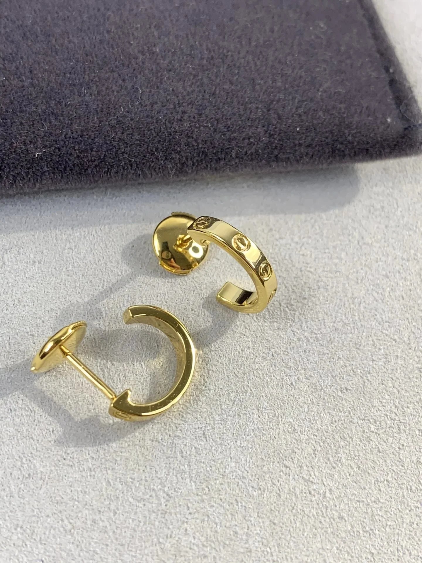 Schmale Ohrstecker im Creolenstil mit Schraubenmotiv in Goldton